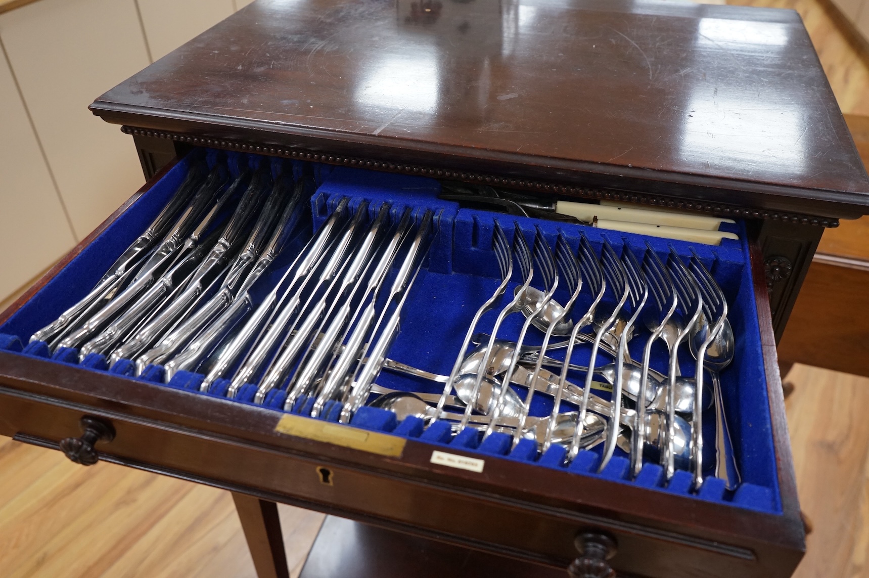 A canteen of cutlery by Viners, contained within a four drawer floor standing cabinet. 110cm tall